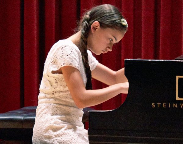 Picture of a young girl playing a piano